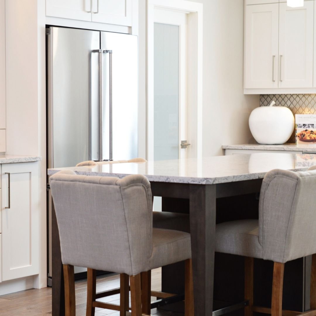 A kitchen with a table and chairs.